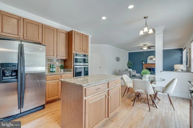 a dining room with wooden floor a chandelier a glass table and chairs