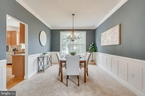 a view of a dining room with furniture and chandelier