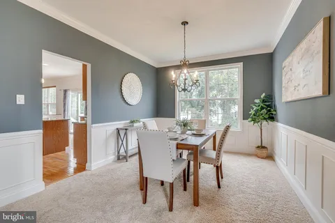 a living room with furniture a rug potted plant and a large window