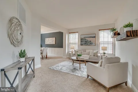 a living room with furniture a chandelier and a large window