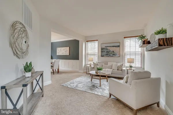 a living room with furniture a chandelier and a large window