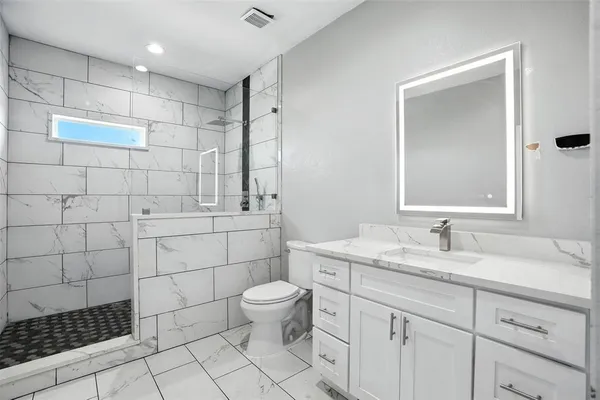 a bathroom with a sink toilet and shower