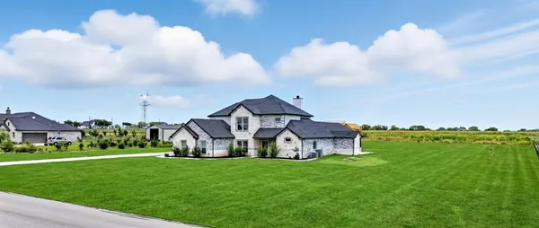 a view of a house with a big yard and large trees