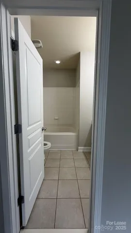 an empty room with a chandelier fan and windows