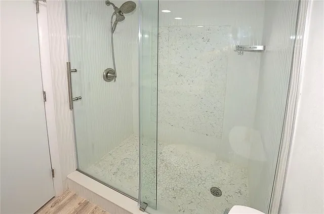a bathroom with a granite countertop sink mirror vanity and toilet