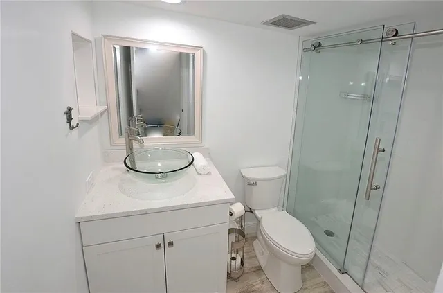 a bathroom with a toilet a sink and mirror