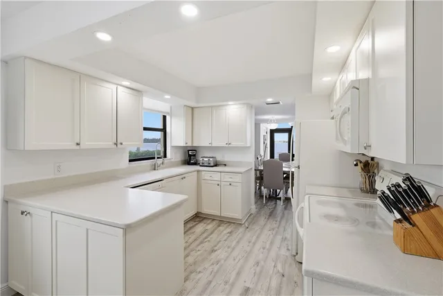 a kitchen that has a lot of cabinets a sink and appliances in it