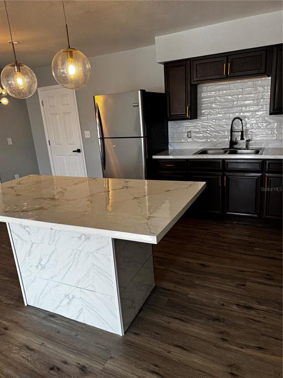 409 Fern Road Winter Haven, FL 33880 - Photo 21 of 21 a kitchen with stainless steel appliances wooden floor sink and wooden cabinets