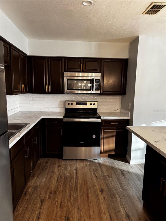 409 Fern Road Winter Haven, FL 33880 - Photo 4 of 21 a kitchen with a stove and a microwave