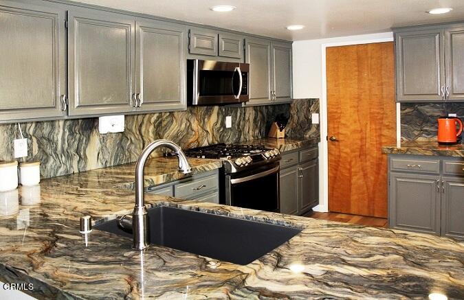 26963 Calamine Drive Calabasas, CA 91301 - Photo 9 of 31 a kitchen with stainless steel appliances granite countertop a stove and a refrigerator
