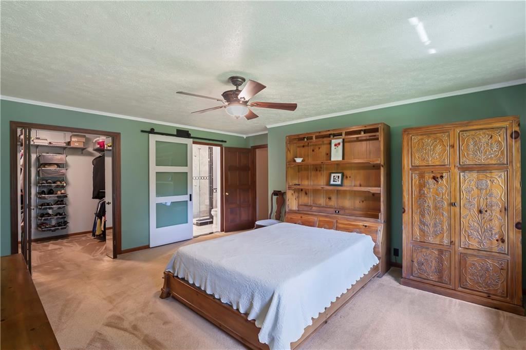 143 Lynn Road Washington, PA 15301 - Photo 14 of 25 a spacious bedroom with a large bed and a chandelier