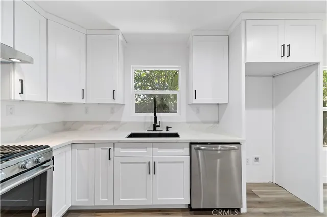 a kitchen with white cabinets and appliances