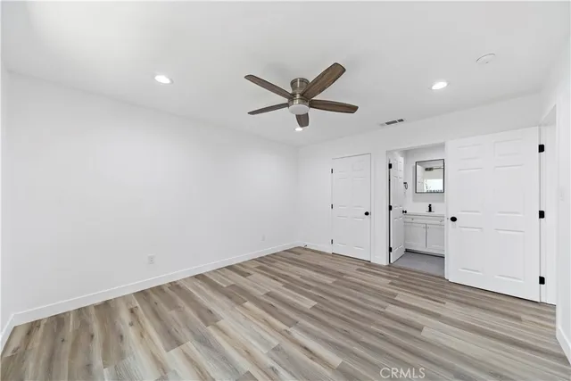 an empty room with closet and a ceiling fan