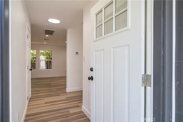 a view of a hallway with wooden floor and entryway