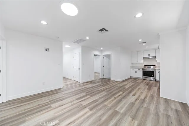 a view of a kitchen with kitchen island a sink wooden floor and a refrigerator