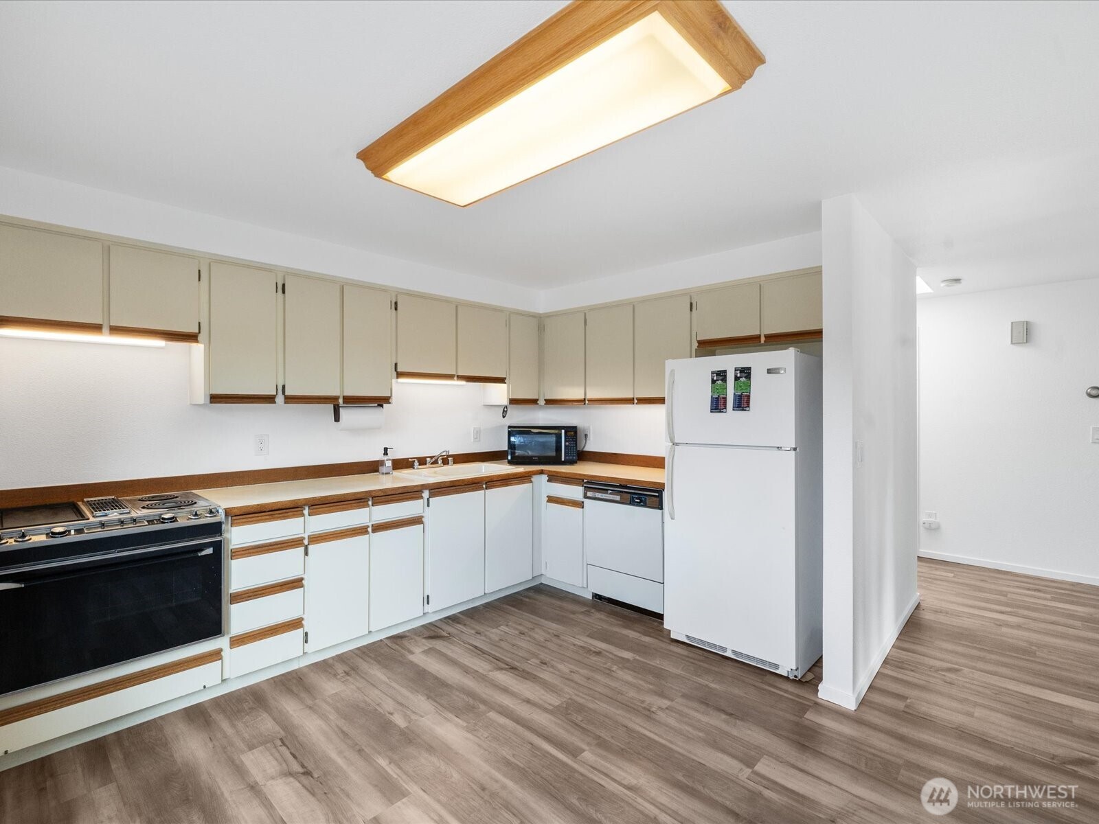 8225 212th Street Southwest, Unit 302 Edmonds, WA 98026 - Photo 4 of 16 a kitchen with granite countertop white cabinets and white appliances