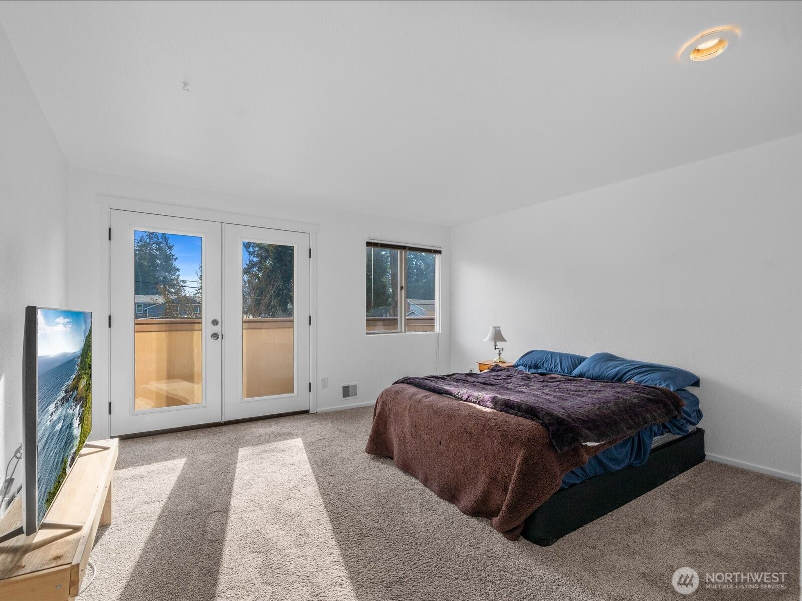 8225 212th Street Southwest, Unit 302 Edmonds, WA 98026 - Photo 6 of 16 a bedroom with a bed and a flat screen tv