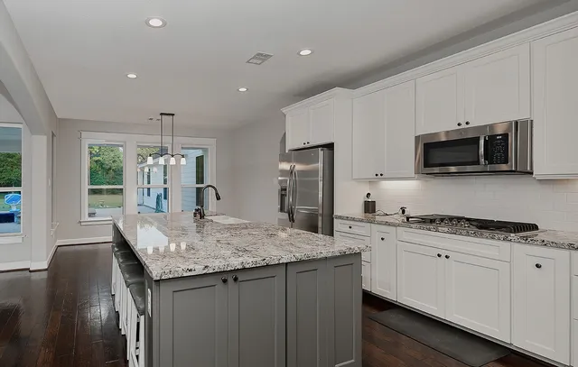 a view of wooden floor and a chandelier fan in a room