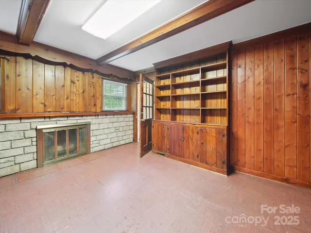an empty room with a fireplace and cabinet