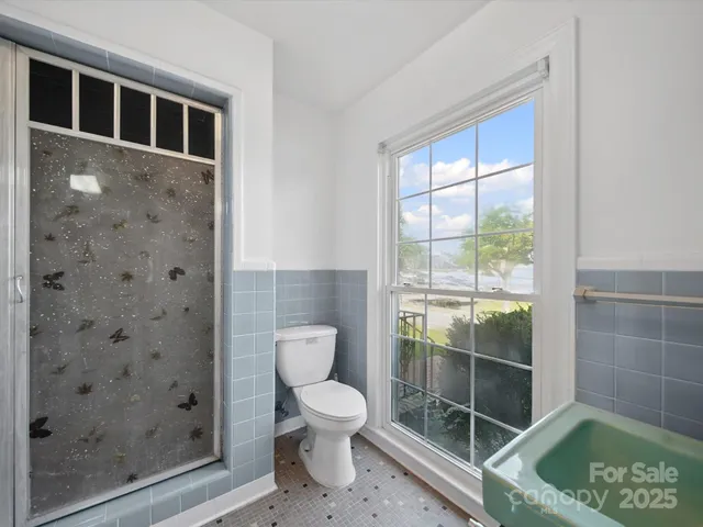 a bathroom with a toilet and a shower