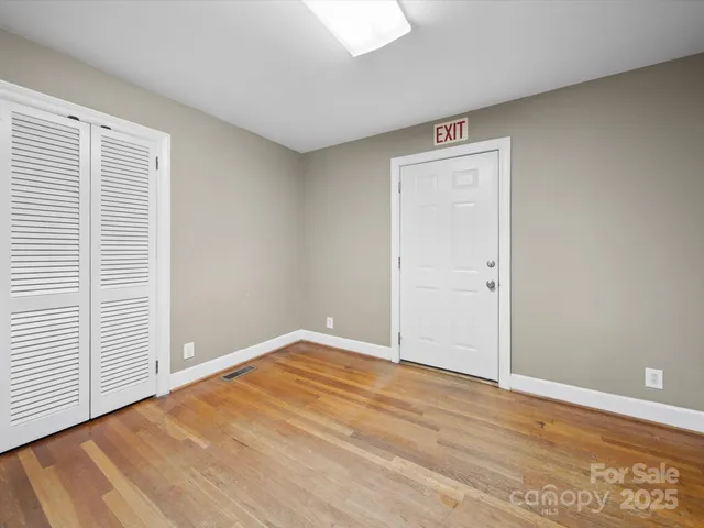 an empty room with wooden floor and closet