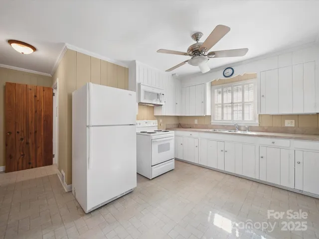 a kitchen with white cabinets and white appliances