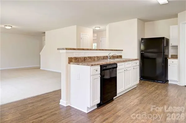 a kitchen with a stove top oven and refrigerator