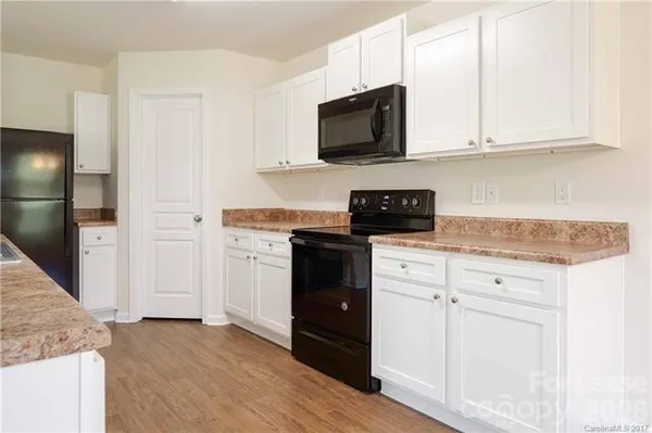a kitchen with granite countertop white cabinets and stainless steel appliances