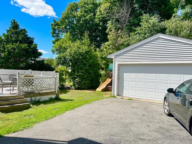 a view of a patio with couches table and chairs with wooden floor and fence