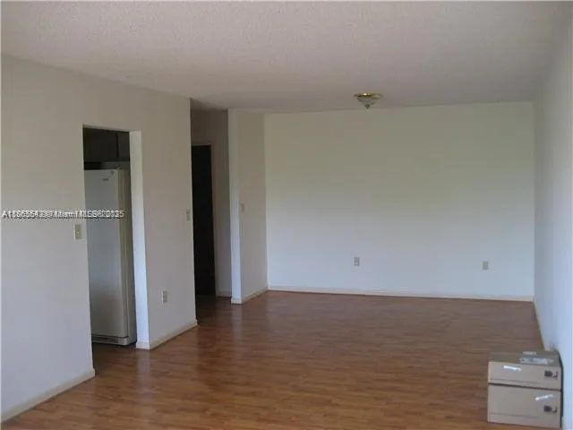 a view of an empty room and wooden floor