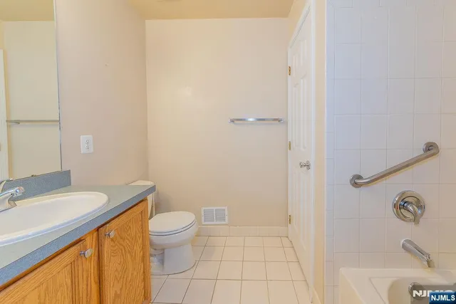 a bathroom with a granite countertop sink a toilet and a bathtub