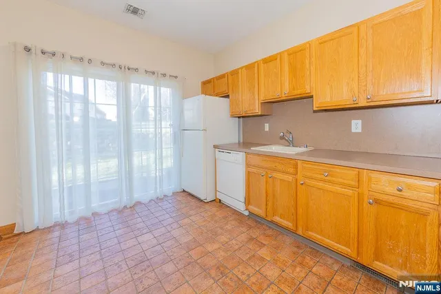 a view of a kitchen with wooden floor and cabinets