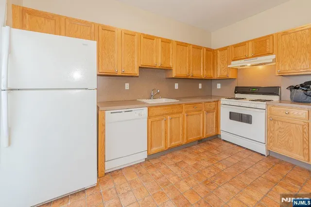 a kitchen with a sink a stove a refrigerator and cabinets