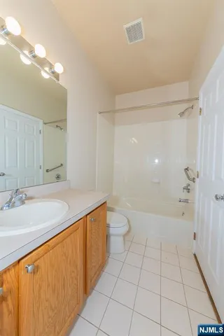 a bathroom with a granite countertop sink a toilet and shower