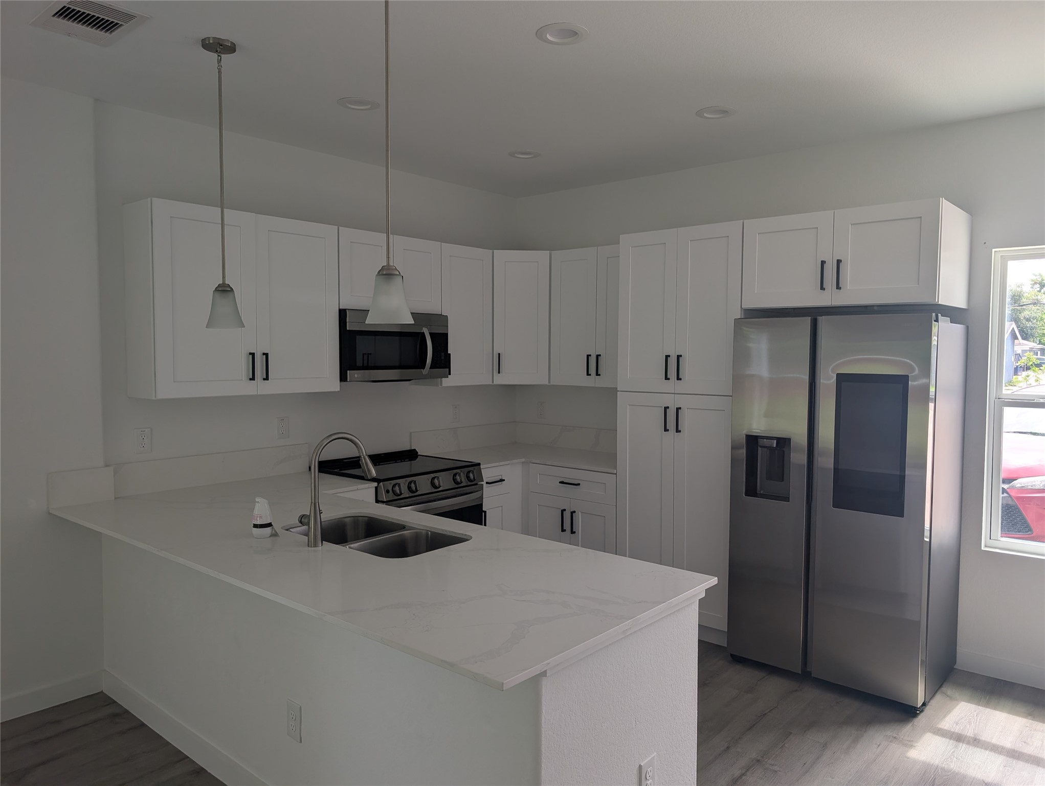 7813 Hirsch Road, Unit B Houston, TX 77016 - Photo 4 of 8 a kitchen with stainless steel appliances a stove a refrigerator a sink a microwave and cabinets