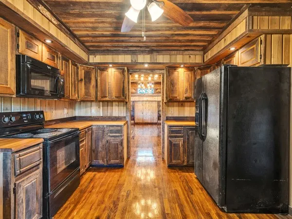 a kitchen with granite countertop a refrigerator and wooden cabinets