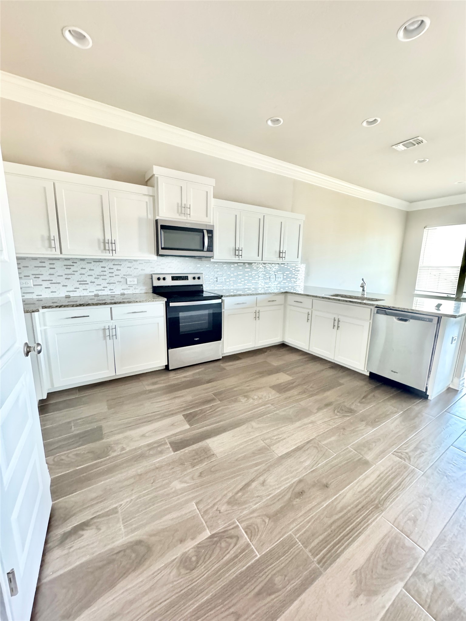 105 Everett Court, Unit B Jarrell, TX 76537 - Photo 3 of 16 a kitchen with stainless steel appliances granite countertop a stove and a sink