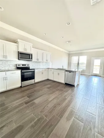 a kitchen with wooden floors and appliances