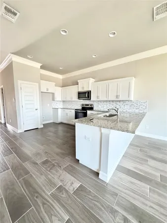 a kitchen with stainless steel appliances granite countertop a stove a sink and a refrigerator
