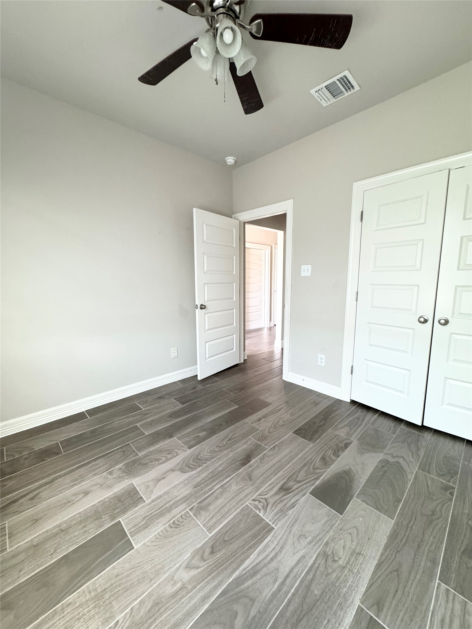 105 Everett Court, Unit B Jarrell, TX 76537 - Photo 10 of 16 an empty room with wooden floor and ceiling fan