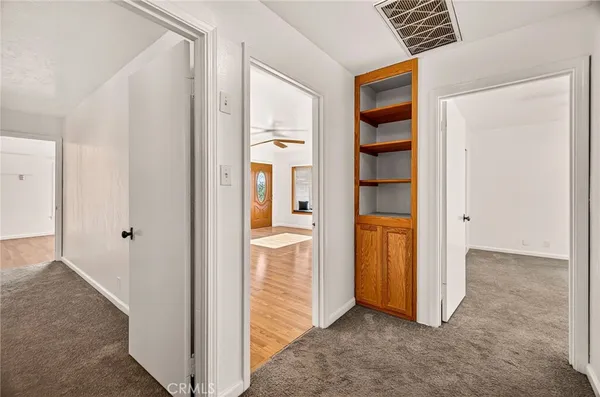 an empty room with windows and ceiling fan