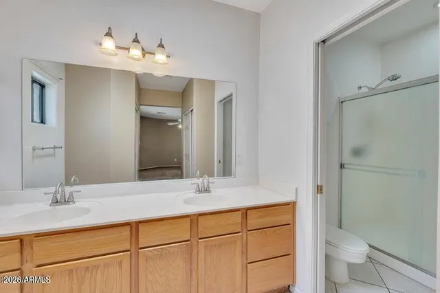 a bathroom with a double vanity sink toilet and shower