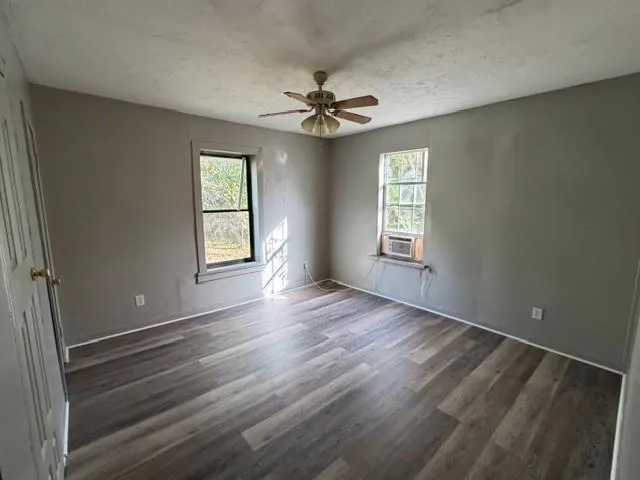 wooden floor in an empty room with a window