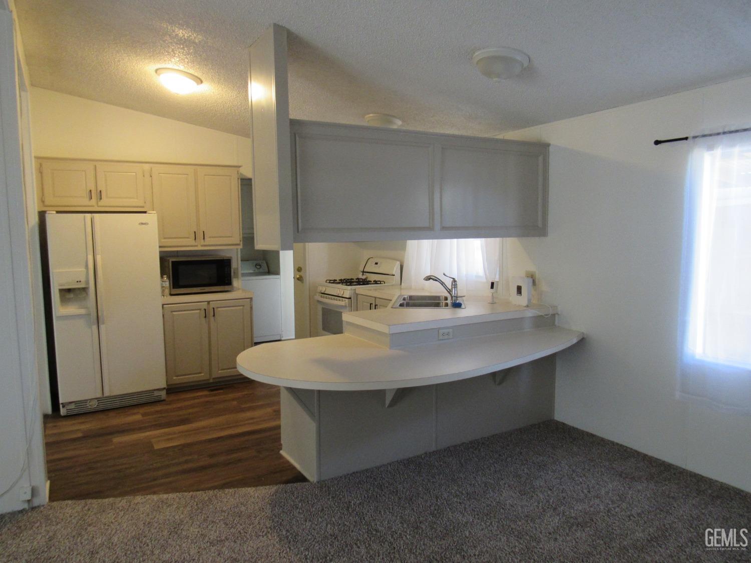 Undisclosed Address Bakersfield, CA 93304 - Photo 5 of 26 a kitchen with stainless steel appliances a sink and refrigerator