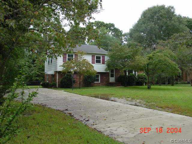 a front view of a house with a yard and trees