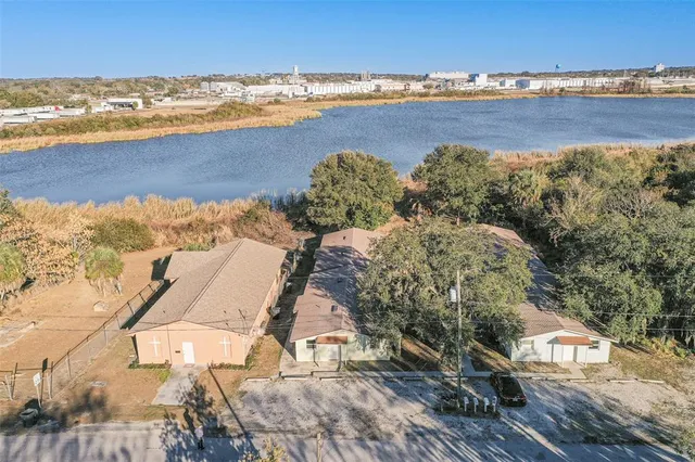 an aerial view of residential houses with outdoor space and trees