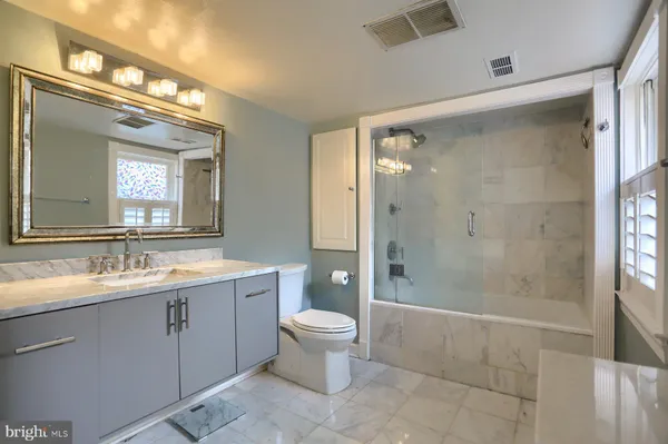 a spacious bathroom with a granite countertop sink a mirror and a shower