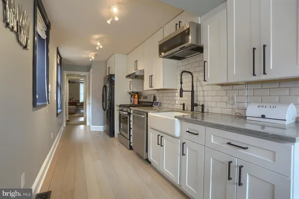a kitchen with white cabinets stainless steel appliances and sink