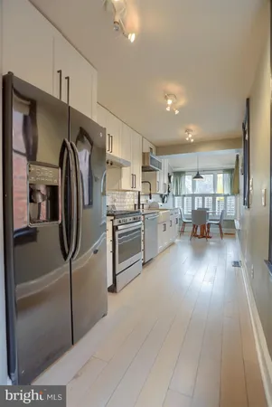 a kitchen with stainless steel appliances granite countertop a refrigerator and a stove