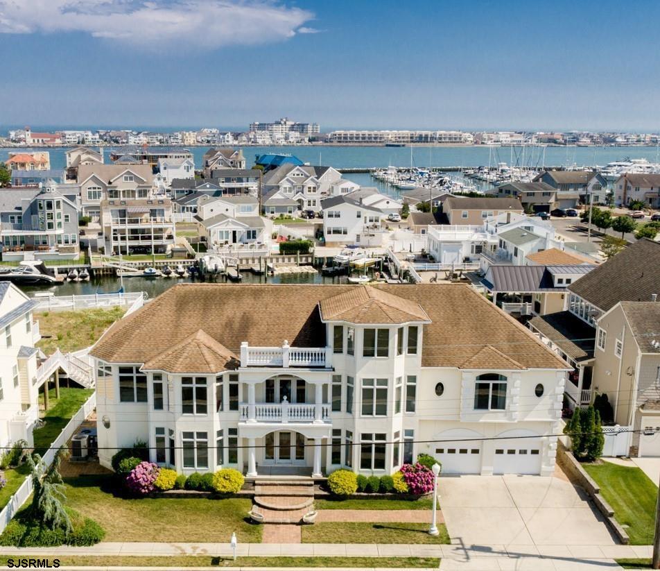 an aerial view of residential houses with yard and ocean view